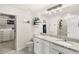 Bathroom with granite countertops, dual sinks, a large mirror, walk-in closet and updated fixtures at 7603 Taormina Way, Clermont, FL 34714