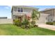 Home exterior with a landscaped front yard and two car garage on a sunny day at 7603 Taormina Way, Clermont, FL 34714