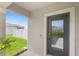 View of front door with glass panel and smart doorbell; lawn visible at 7603 Taormina Way, Clermont, FL 34714