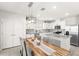 Well-lit kitchen and dining area with wood table, grey chairs, granite countertops and stainless steel appliances at 7603 Taormina Way, Clermont, FL 34714