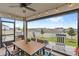 Screened patio with ceiling fan, string lights, backyard views, and a dining set at 7603 Taormina Way, Clermont, FL 34714