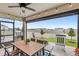 Screened patio with a ceiling fan, string lights, and an outdoor table with view of the yard at 7603 Taormina Way, Clermont, FL 34714