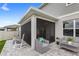 Covered and screened outdoor patio with gray wicker furniture and rocking chairs at 7603 Taormina Way, Clermont, FL 34714