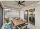 Covered patio with stylish outdoor seating, ceiling fan, and scenic backyard view at 7603 Taormina Way, Clermont, FL 34714