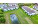 Aerial view of a well-maintained townhome community, showcasing serene pond views and lush landscaping at 812 Benoi Dr, Davenport, FL 33896