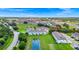 Aerial view of a townhome complex with pond and highway views, landscaped lawns, and street parking at 812 Benoi Dr, Davenport, FL 33896