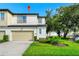 Charming two-story townhouse features a light beige garage and a bright green front lawn at 812 Benoi Dr, Davenport, FL 33896