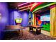 Colorful game room with billiards, ping pong table, video game monitor and a funky carpet at 812 Benoi Dr, Davenport, FL 33896