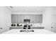 Bright kitchen featuring gray cabinets, a large center island, and modern appliances at 812 Benoi Dr, Davenport, FL 33896