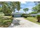 A well-maintained exterior with a large driveway and mature trees in a large front yard at 945 Shawna Shrs, Haines City, FL 33844