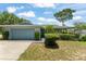 A well-maintained exterior with a two-car garage and a lush front yard with trimmed bushes at 945 Shawna Shrs, Haines City, FL 33844