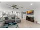 Open-concept living area showcasing a gray sofa, kitchen with a breakfast bar, and a flat-screen television at 945 Shawna Shrs, Haines City, FL 33844