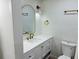 Bathroom with sleek white vanity, stylish mirror, and modern fixtures at 1055 Kensington Park Dr # 205, Altamonte Springs, FL 32714