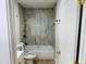 Bathroom with a white tub, neutral tile, and bronze fixtures at 1055 Kensington Park Dr # 205, Altamonte Springs, FL 32714