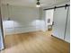 Bedroom with paneled wall detail, ceiling fan, and sliding barn door to en-suite bathroom at 1055 Kensington Park Dr # 205, Altamonte Springs, FL 32714