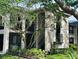 Exterior view of a two-story home with balconies, mature trees, and lush landscaping at 1055 Kensington Park Dr # 205, Altamonte Springs, FL 32714