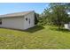 Backyard view of the home showing lush lawn, screened patio and perimeter trees at 10708 Brice Ct, Orlando, FL 32817