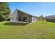 Backyard view of the home with the screened patio, lawn and partial fencing at 10708 Brice Ct, Orlando, FL 32817