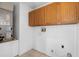 Laundry room with tile floors and wooden cabinets above the washer and dryer hookups at 10708 Brice Ct, Orlando, FL 32817