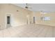 Large living room with tile floors, high ceilings, ceiling fan, and view of kitchen at 10708 Brice Ct, Orlando, FL 32817