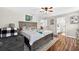 This bedroom has wood-look floors, ceiling fan, a bed, and a doorway to an adjacent bathroom at 1224 Blackwater Pond Dr, Orlando, FL 32828
