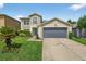 Charming two-story home featuring well-manicured lawn and a gray two-car garage door at 1224 Blackwater Pond Dr, Orlando, FL 32828