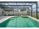 View of a screened in pool with a hammock and spa at 1224 Blackwater Pond Dr, Orlando, FL 32828