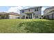 Backyard view of home, covered porch, sliding glass door, and neighboring houses at 1292 Cavender Creek Rd, Minneola, FL 34715
