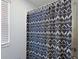 Shower with modern black and white patterned shower curtain and window at 1292 Cavender Creek Rd, Minneola, FL 34715
