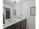Bathroom with double sinks, quartz countertops, framed art, and a peek into the shower at 1292 Cavender Creek Rd, Minneola, FL 34715