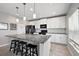 Bright kitchen features white cabinetry, black appliances, granite countertops, and a convenient center island with barstool seating at 1292 Cavender Creek Rd, Minneola, FL 34715