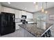 Kitchen featuring stainless sink and faucet surrounded by stainless appliances, white cabinets and granite countertops at 1292 Cavender Creek Rd, Minneola, FL 34715