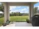 Covered patio showcasing a spacious yard with lush grass and an iron fence overlooking a treed horizon at 1292 Cavender Creek Rd, Minneola, FL 34715