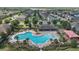 Aerial view of the community pool, showcasing its unique shape, sun loungers, and playground at 1292 Cavender Creek Rd, Minneola, FL 34715