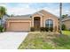 Inviting single-story home with a two-car garage, manicured lawn, and charming front entry at 1456 Sun Meadow Dr, Orlando, FL 32824