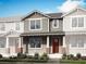Charming two-story home featuring a covered entry, vertical siding, and manicured landscaping at 156 Royal Ranch Rd, Clermont, FL 34715