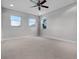 Spacious bedroom with neutral carpet, three windows, and a ceiling fan at 15900 Citrus Knoll Dr, Winter Garden, FL 34787