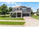 Two-story home featuring a dark gray color scheme, manicured lawn, and a two car garage at 15900 Citrus Knoll Dr, Winter Garden, FL 34787
