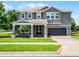 An eye-catching two-story home with a pristine lawn, a manicured landscape, and a brick driveway at 15900 Citrus Knoll Dr, Winter Garden, FL 34787
