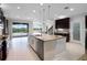 Modern kitchen featuring a granite island, stainless steel appliances, and sliding glass doors to the outdoor area at 15900 Citrus Knoll Dr, Winter Garden, FL 34787