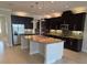 Modern kitchen with dark cabinetry, granite countertops, stainless steel appliances, and an island with a sink at 15900 Citrus Knoll Dr, Winter Garden, FL 34787