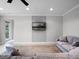 Living room featuring a large sofa, neutral walls, and a wall-mounted television at 15900 Citrus Knoll Dr, Winter Garden, FL 34787