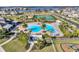 Aerial view of a resort-style pool with palm trees, lounge chairs, and a clubhouse overlooking a lake at 15900 Citrus Knoll Dr, Winter Garden, FL 34787