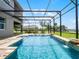Inviting screened-in pool with waterfall feature and travertine tile surround, perfect for outdoor entertaining at 15900 Citrus Knoll Dr, Winter Garden, FL 34787