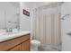 Cozy bathroom featuring a toilet, vanity with sink, and shower with neutral-toned striped curtain at 1593 Osprey View Dr, Apopka, FL 32703