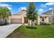 Charming single-story home with a well-manicured lawn, lush landscaping and attached two car garage at 1593 Osprey View Dr, Apopka, FL 32703