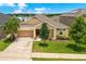 Charming single-story home with a well-manicured lawn, lush landscaping and attached two car garage at 1593 Osprey View Dr, Apopka, FL 32703