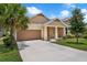 Well-maintained single-Gathering home featuring a two car garage, lush landscaping and concrete driveway at 1593 Osprey View Dr, Apopka, FL 32703