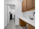 Convenient laundry room with gray tile, utility sink, modern appliances, cabinets, and counter space at 1593 Osprey View Dr, Apopka, FL 32703
