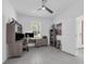 Well-lit home office with a ceiling fan, a window, desk with dual monitors, and gray tiled flooring at 1593 Osprey View Dr, Apopka, FL 32703